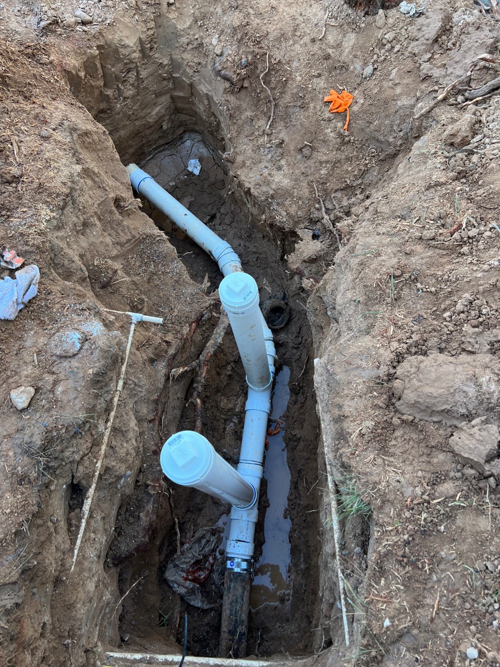 New PVC sewer line laid in an open trench during a full sewer replacement by Omnia Plumbing.