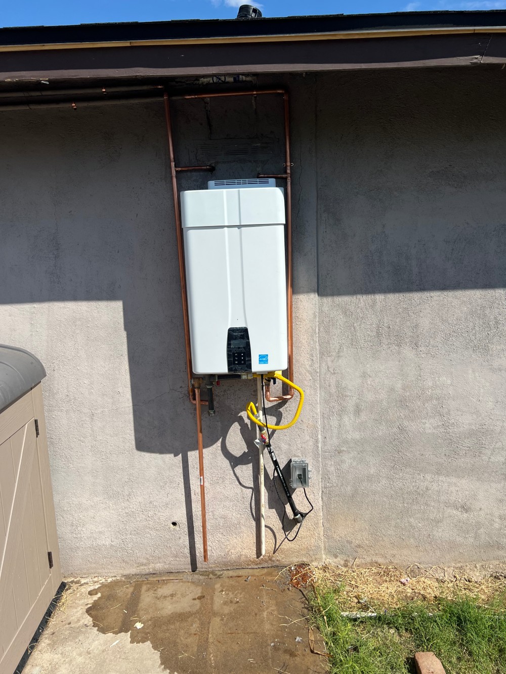 Wall-mounted exterior tankless water heater installation by Omnia Plumbing in the Phoenix metro area.