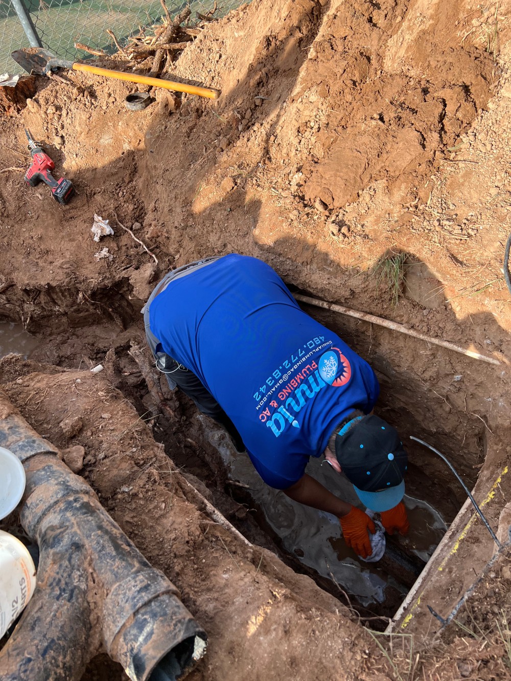 Omnia Plumbing technician working in an excavated trench to repair an underground water line in Scottsdale, Arizona.